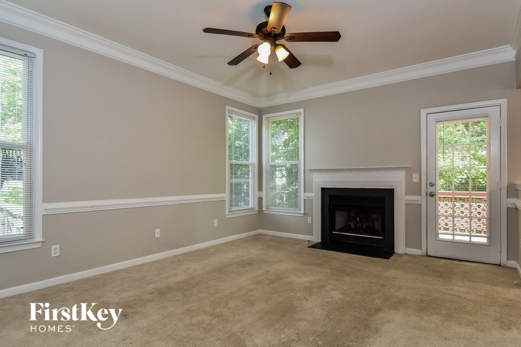 A living room with a fireplace and a ceiling fan.