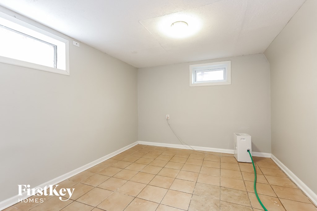 a white room with a tile floor and two windows