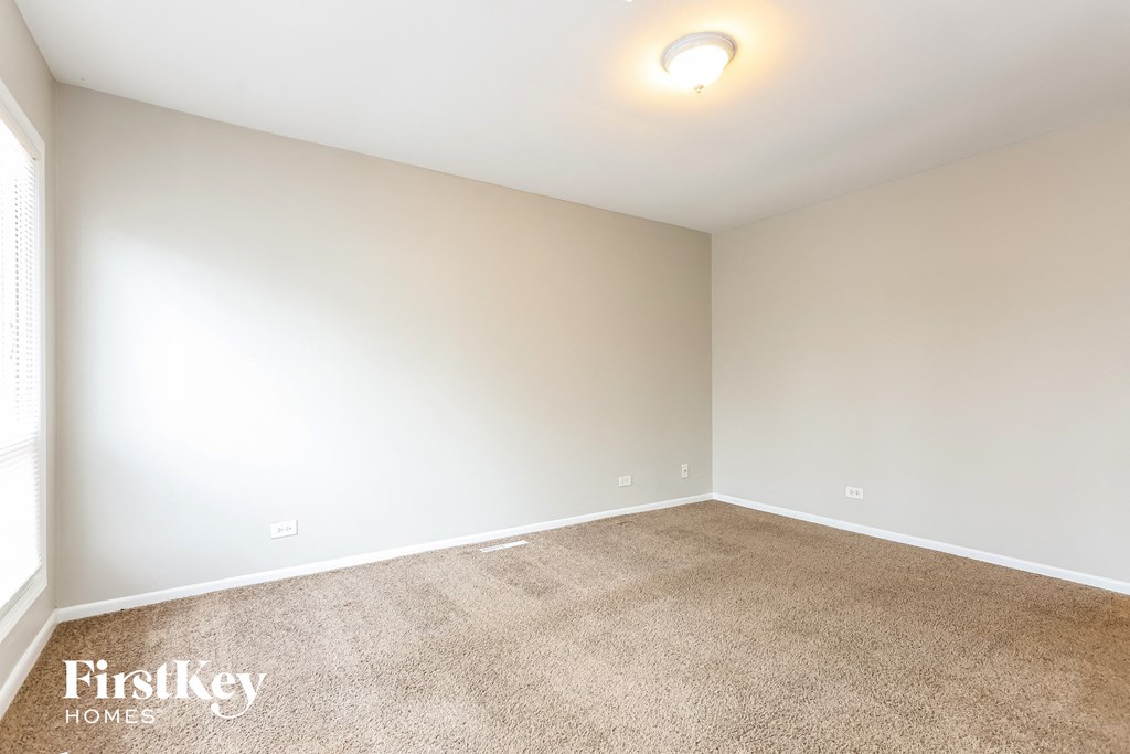 a room with a carpeted floor and a white wall