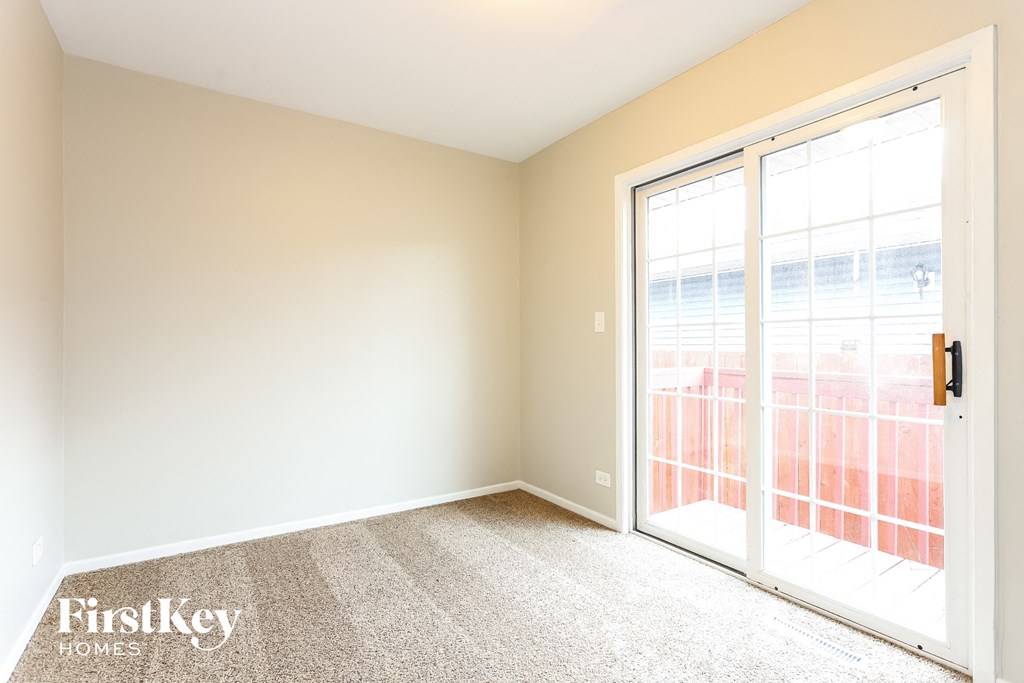 an empty living room with a door to a balcony