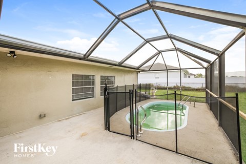 A pool enclosed by a black fence with FirstKey Homes logo.