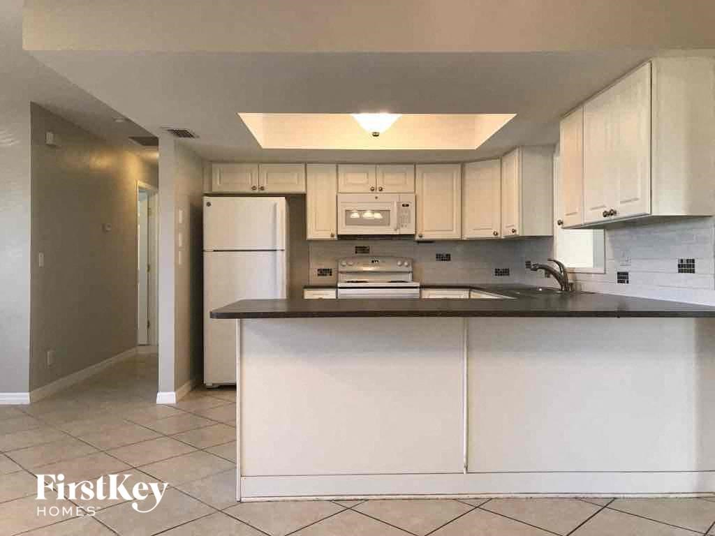 A kitchen with white cabinets and appliances.