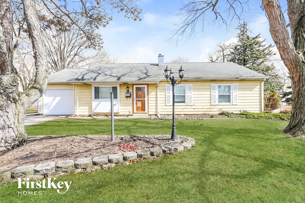 A house with a well-kept lawn and a stone pathway leading to the front door.