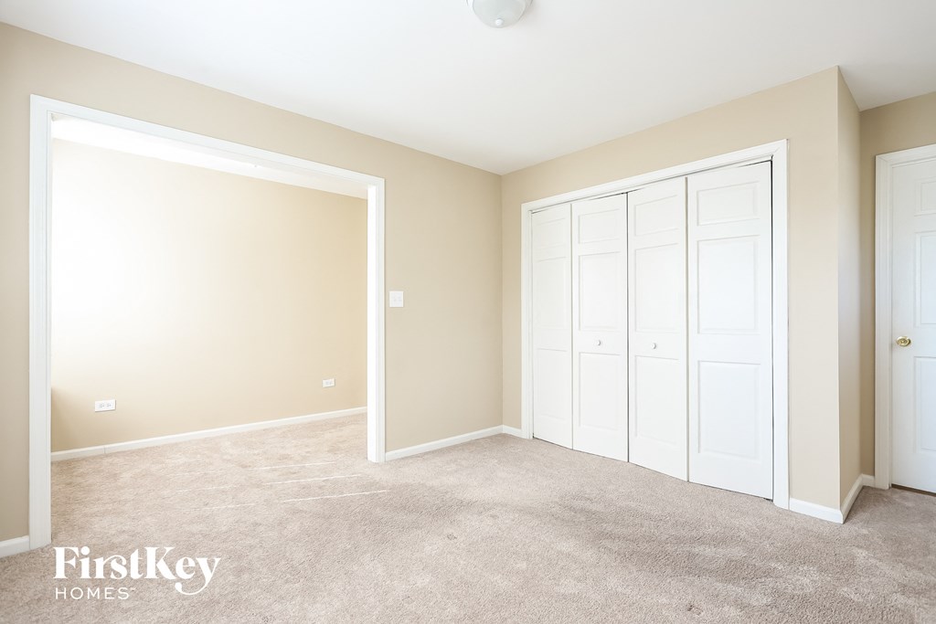 A room with a carpeted floor and a white door.