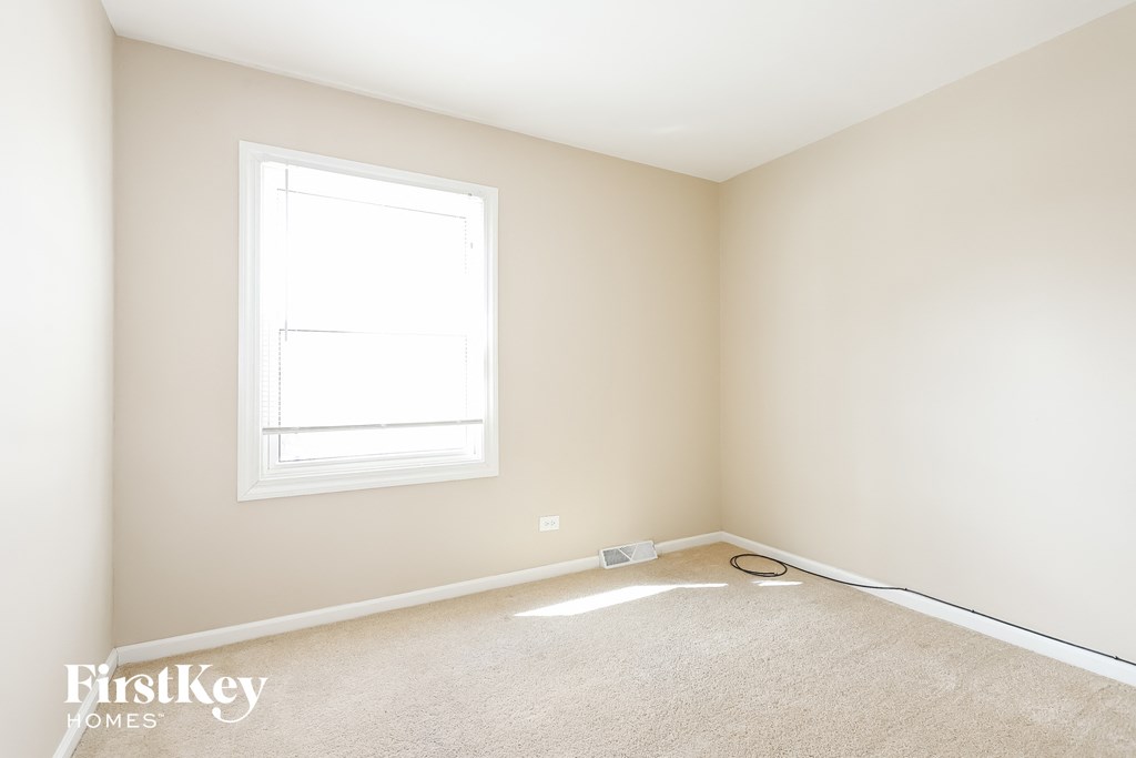 A room with a window and a carpet.