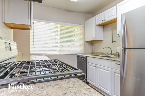 A kitchen with a stove top oven and a refrigerator.