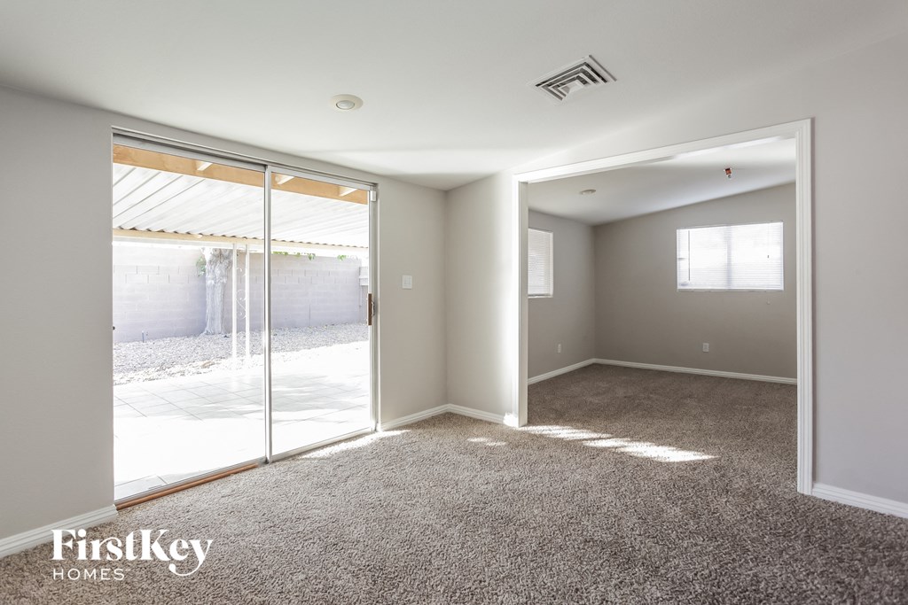 an empty living room with glass doors to a patio