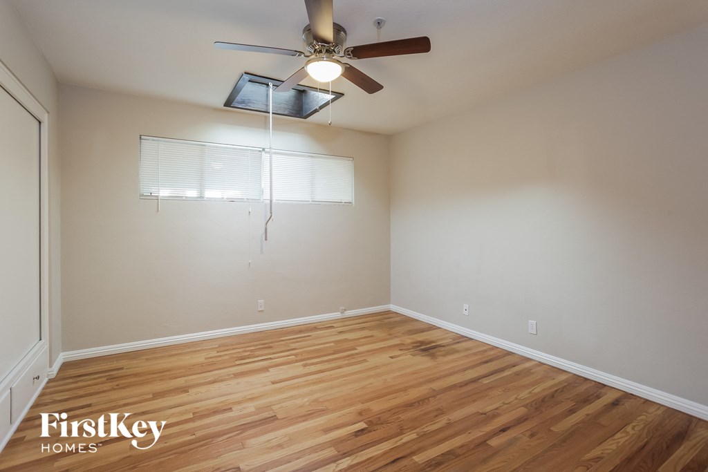a living room with wood floors and a ceiling fan