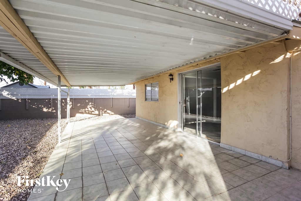 a covered patio under a roof with a sliding glass door