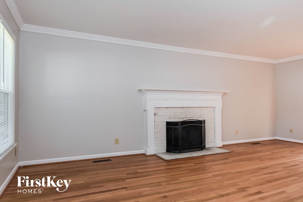 A room with a fireplace and wooden floors.
