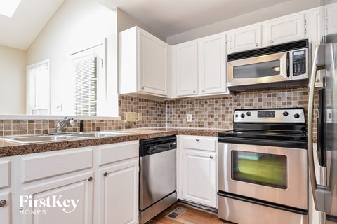 A kitchen with a stove top oven and a microwave above it.
