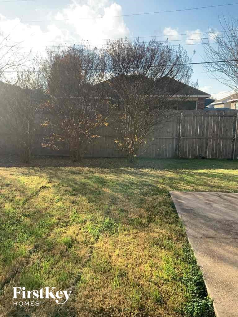 the backyard of a house with a yard and a fence