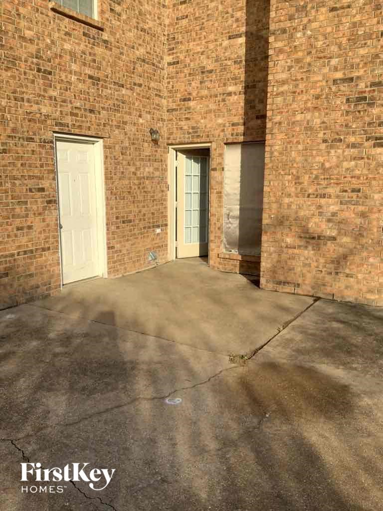 an empty driveway in front of a brick building