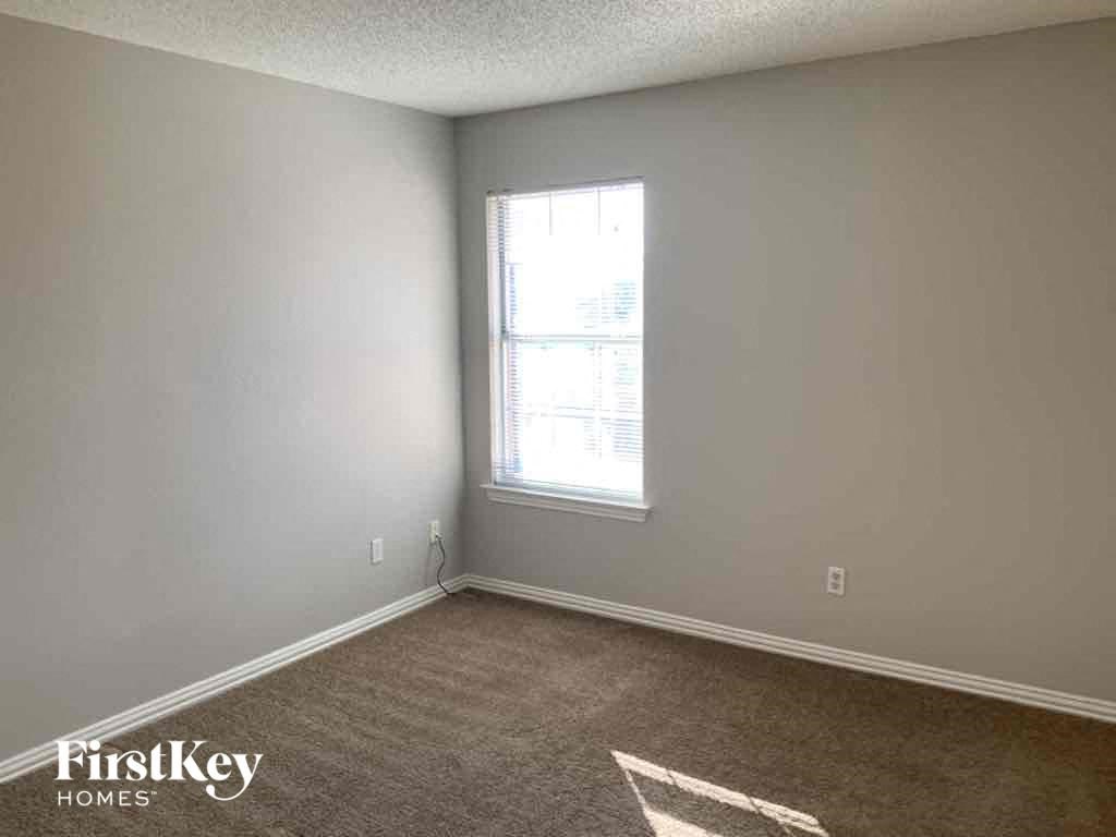 a bedroom with a window and a carpeted floor