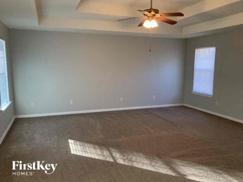 an empty living room with a ceiling fan