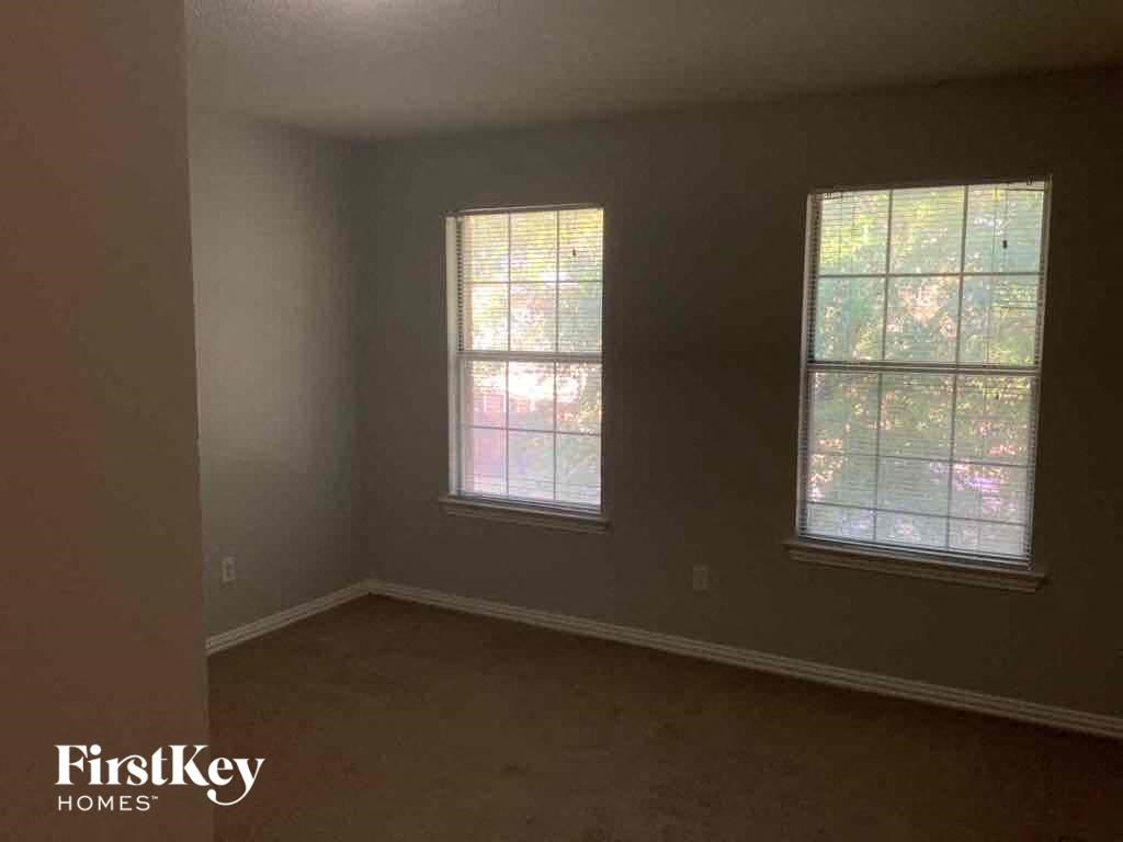 an empty room in a house with two windows