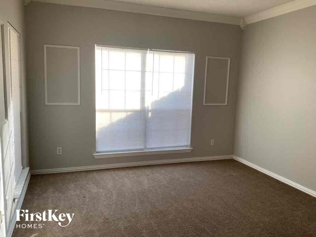 an empty room with a window and a carpet