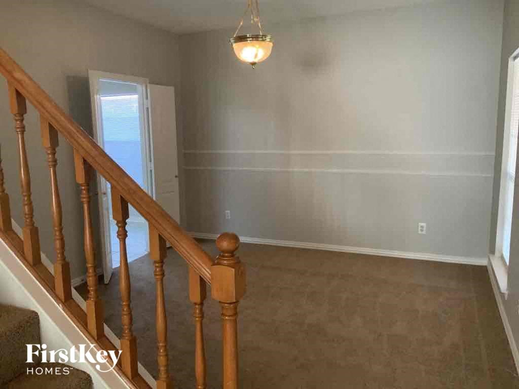 a empty living room with a staircase and a light fixture on the ceiling
