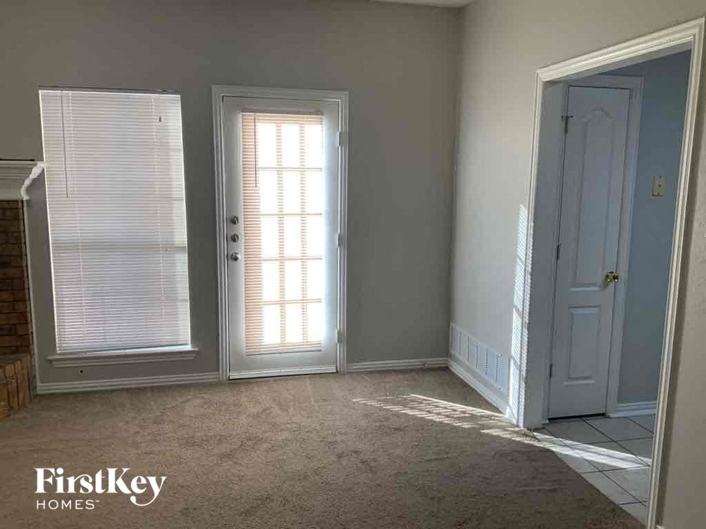 a room with a door and a window and a carpeted floor