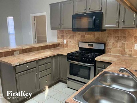 a kitchen with a sink and a stove and a microwave