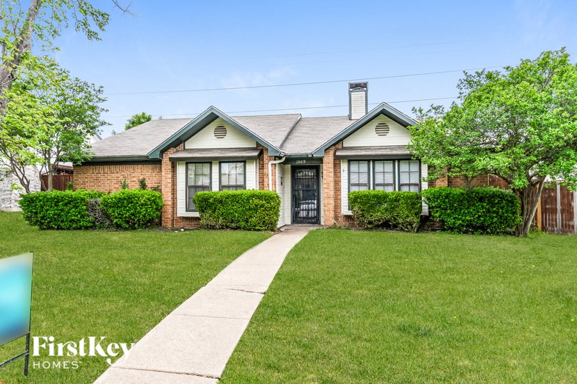 a brick house with a sidewalk in front of it