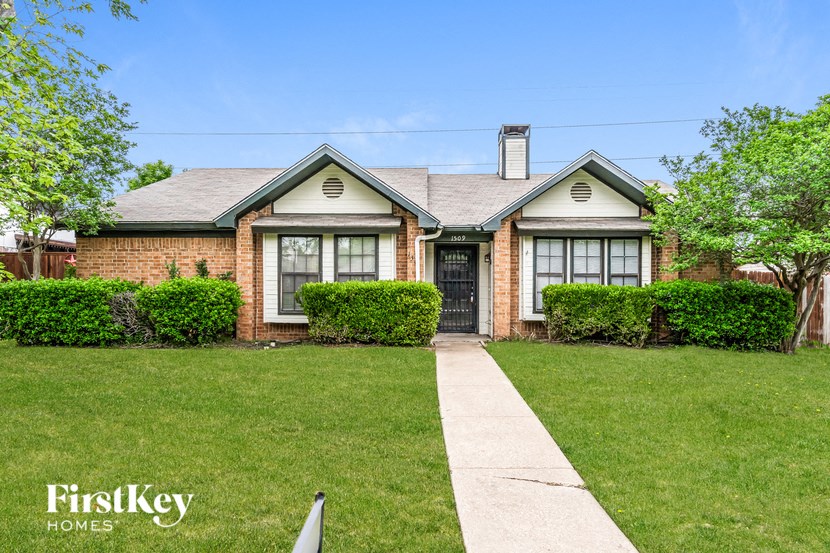 a small brick house with a sidewalk in front of it