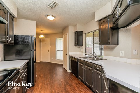 a kitchen with black appliances and white counter tops