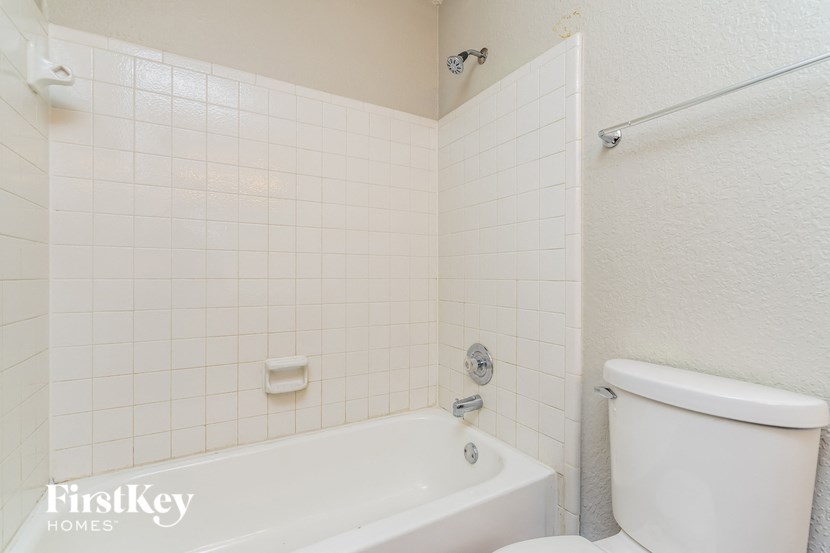 a white bathroom with a toilet and a tub