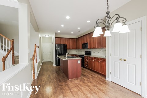 A kitchen with wooden cabinets and a red island.