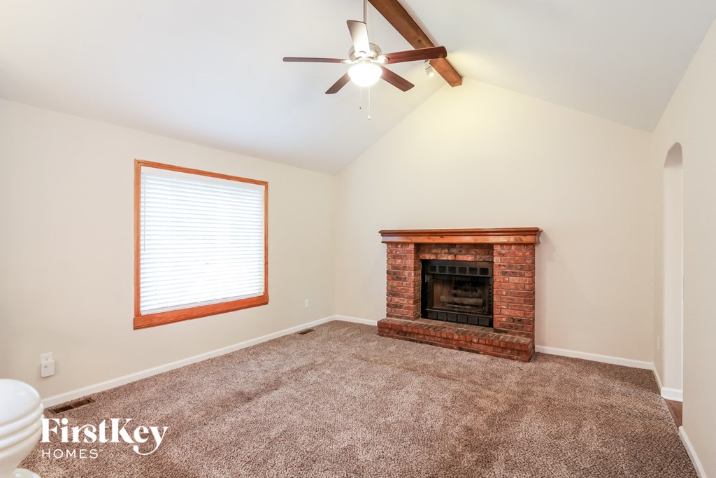 A room with a fireplace and a ceiling fan.