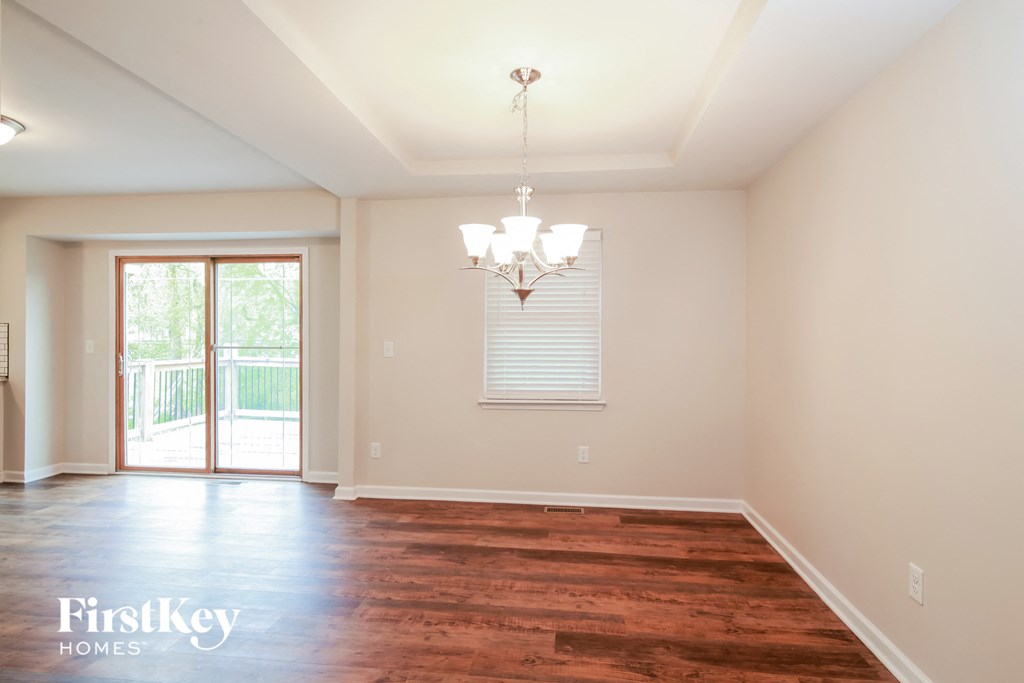 A room with wooden floors and a chandelier.