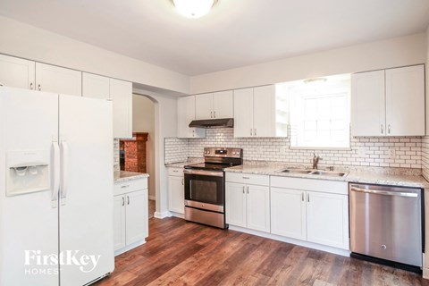 A kitchen with white cabinets and a stainless steel dishwasher.