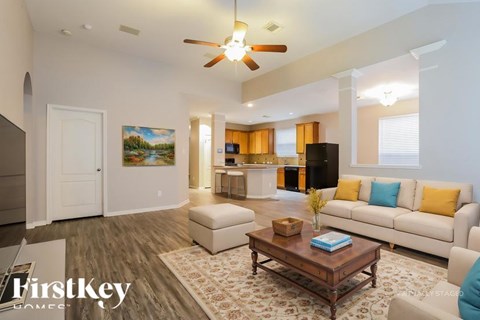 A living room with a white couch, a coffee table, and a painting on the wall.