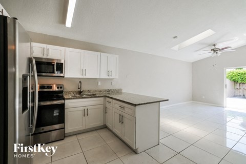 a kitchen with white cabinets and stainless steel appliances
