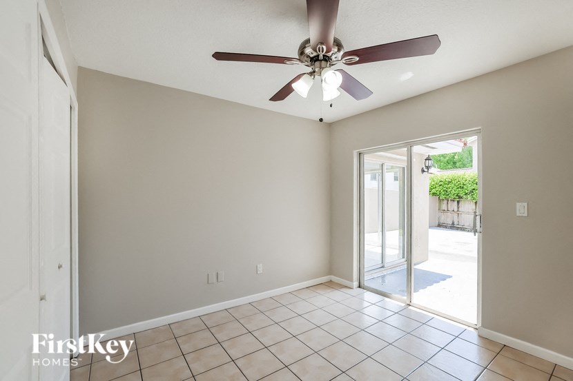 a living room with a ceiling fan and a tiled floor