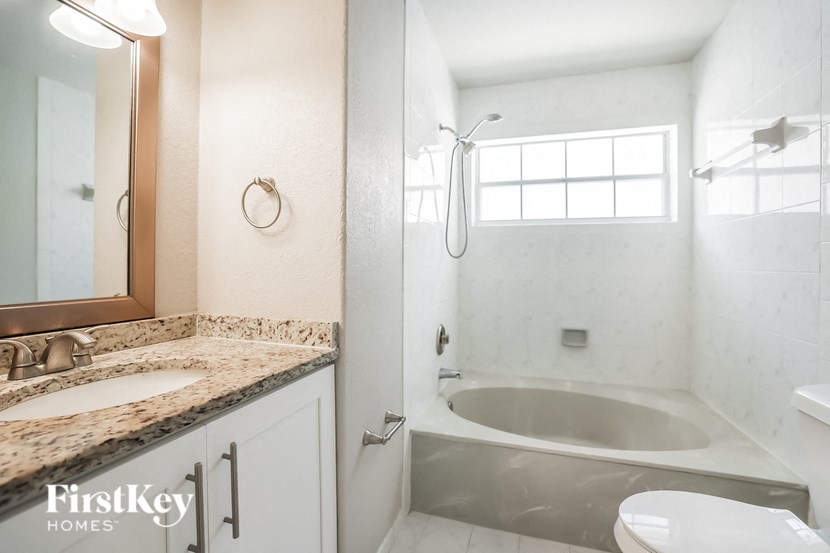 a bathroom with a tub and a sink and a mirror