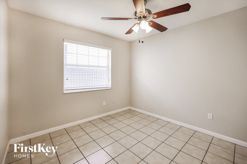a living room with a ceiling fan and a tiled floor