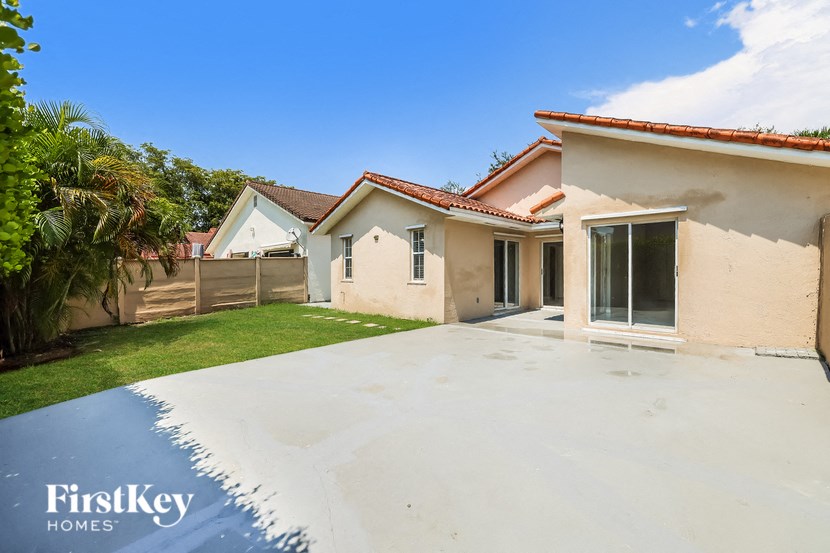 a white driveway in front of a house with a yard