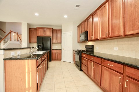 A kitchen with wooden cabinets and black appliances.