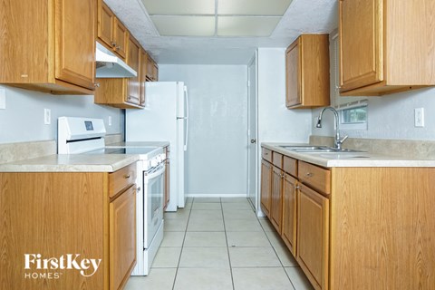 A kitchen with wooden cabinets and a white refrigerator.
