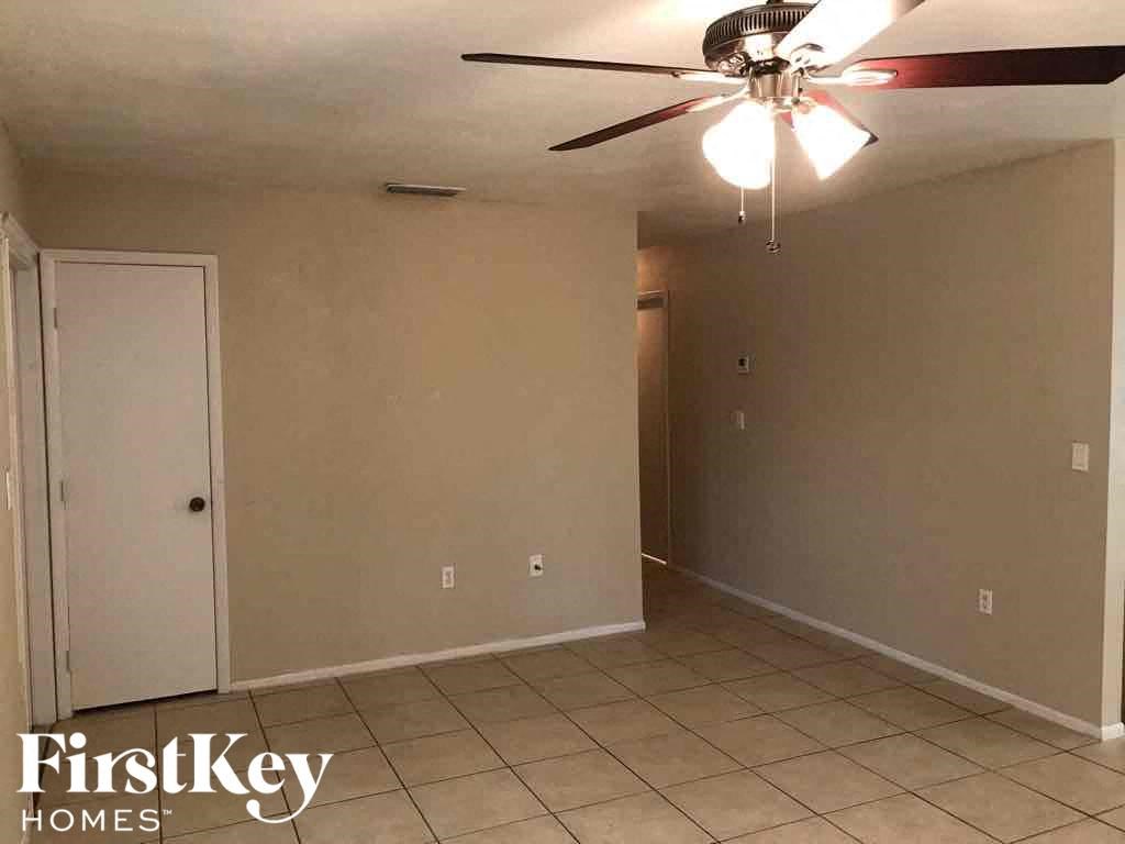 A room with a ceiling fan and tile flooring.