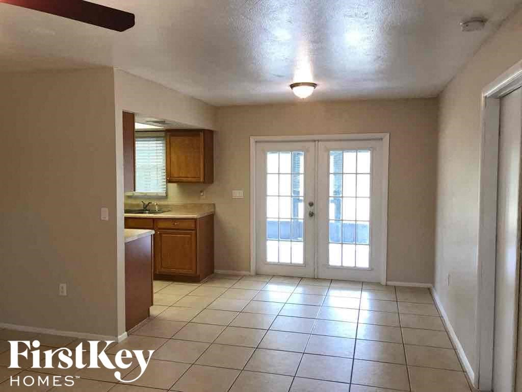 A kitchen area with a sink, cabinets, and a window.