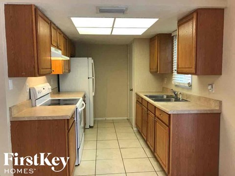 A kitchen with wooden cabinets and a white refrigerator.