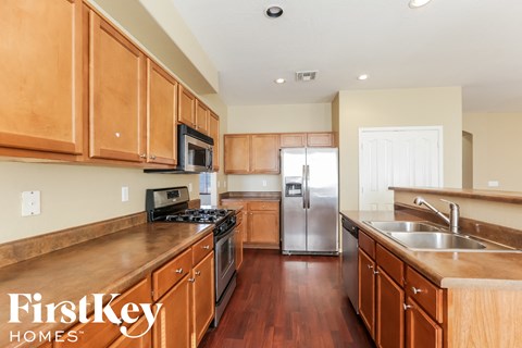 A kitchen with wooden cabinets and a stainless steel refrigerator.