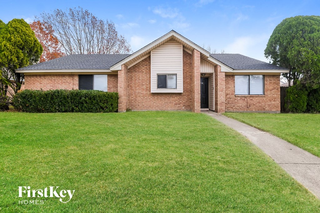 A brick house with a lawn in front of it.
