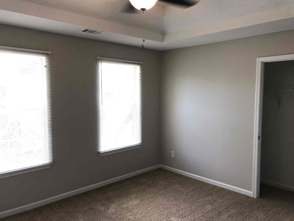 an empty room with two windows and a door