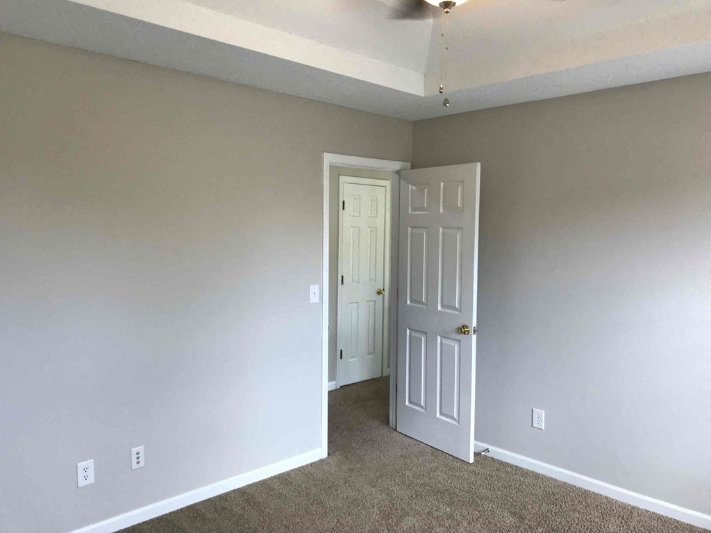 a room with a white door and a carpeted floor