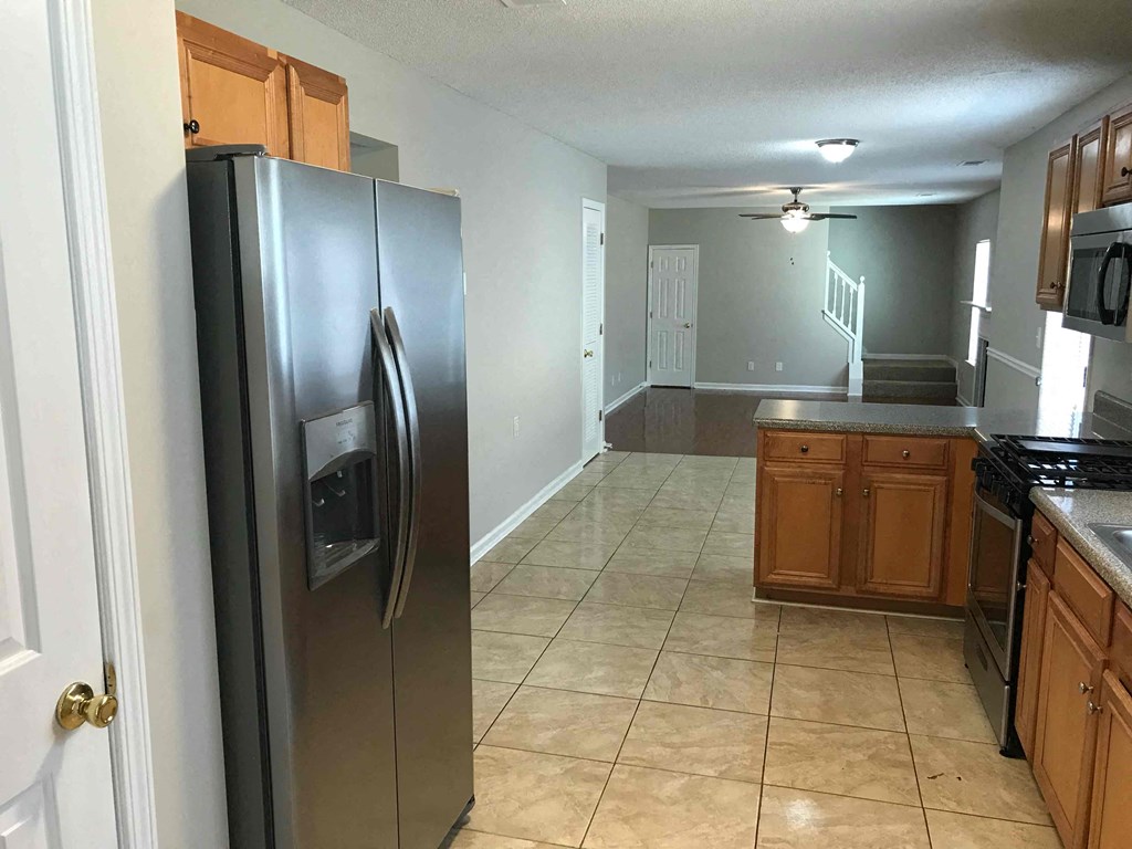 a kitchen with a stainless steel refrigerator