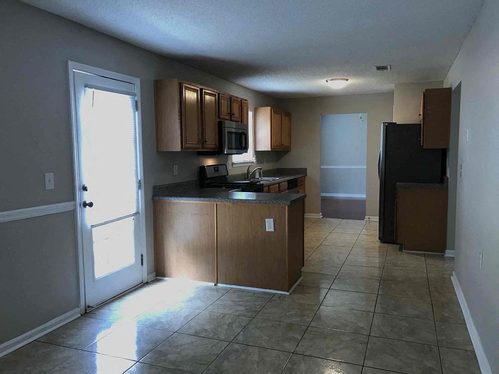 an empty kitchen with a door to the living room