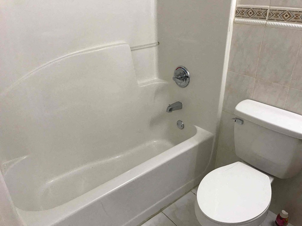 a bathroom with a toilet and a bath tub